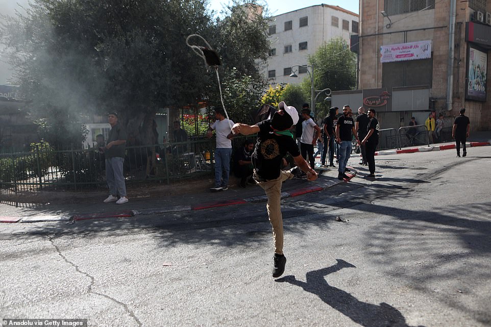 WEST BANK: Palestinians burn tires and throw objects in response to Israeli forces' intervention to their protest against Israeli attacks in Hebron, West Bank on Friday