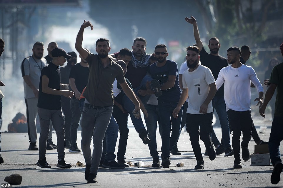 WEST BANK: Palestinian demonstrators carry injured during clashes with Israeli forces following a demonstration in support of the Gaza Strip in the West Bank city of Nablus on Friday