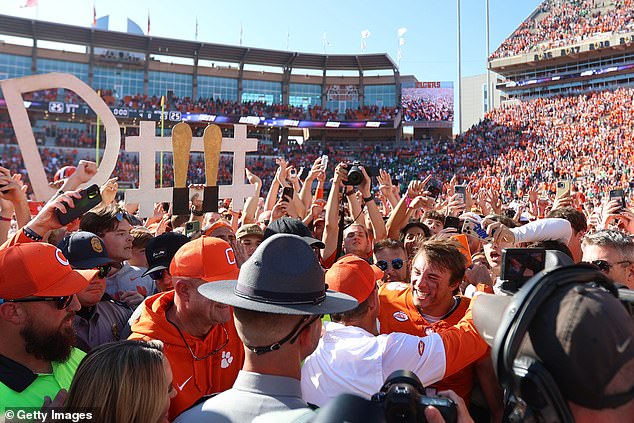 Cade Klubnik of the Clemson Tigers hugs Swinney during an on-field interview