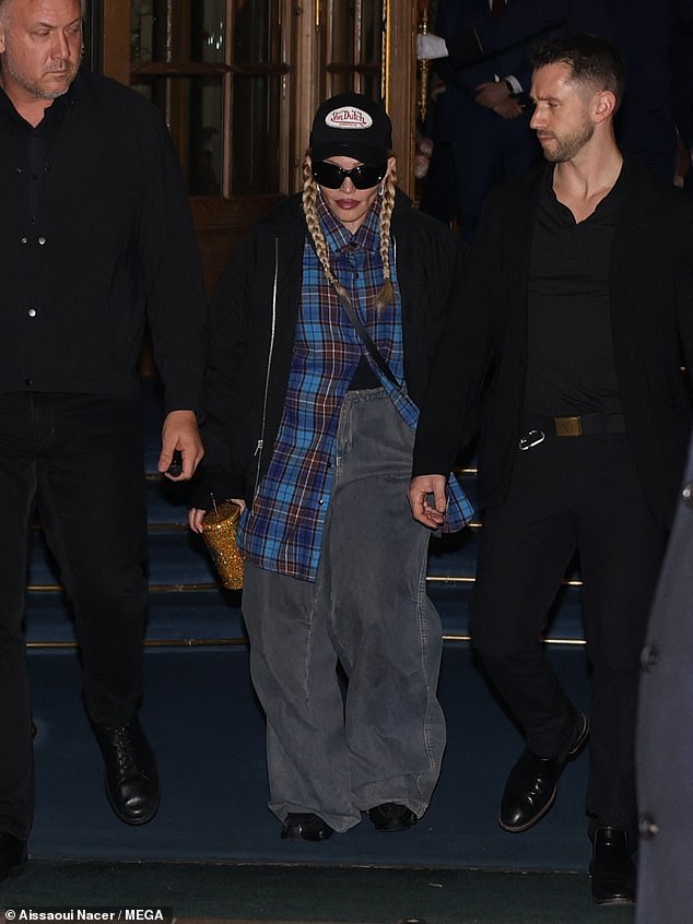 Cool: She also wore a black baseball cap and very baggy grey jeans and smiled as she left the Ritz Hotel, flanked by two bodyguards