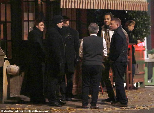 For the evening out, Guy cut a casual figure in a long-sleeved black top and trousers, which he styled with a navy gilet and brown loafers