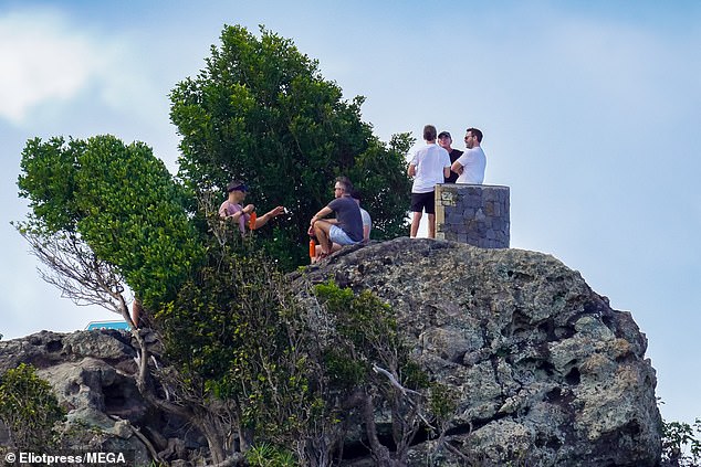 The group was photographed taking in the views on top of a large rock formation