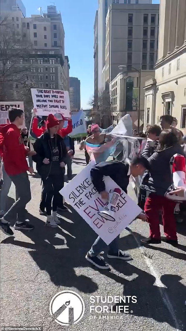 The activist ran through the group, knocking the glasses off one of the anti abortion protestors