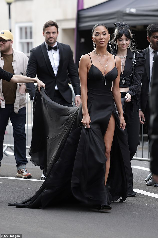Nicole Scherzinger, 45, received a helping hand as she and fiancé Thom Evans, 38, arrived at the star-studded Olivier Awards on Sunday