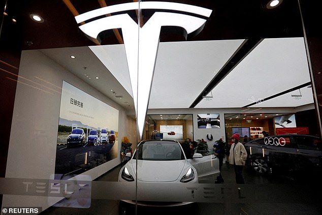 Visitors check a Tesla Model 3 car next to a Model Y displayed at a showroom of the US electric vehicle (EV) maker in Beijing, China February 4, 2023