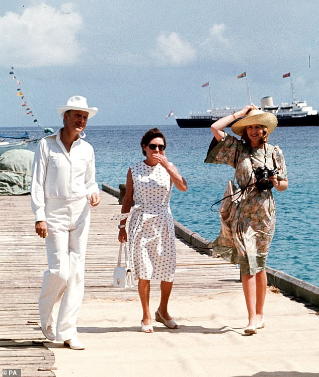 Princess Margaret, centre, and her friends Lord Colin Tennant (left) and Lady Anne Tennant waiting on the jetty at Mustique to greet Queen Elizabeth II