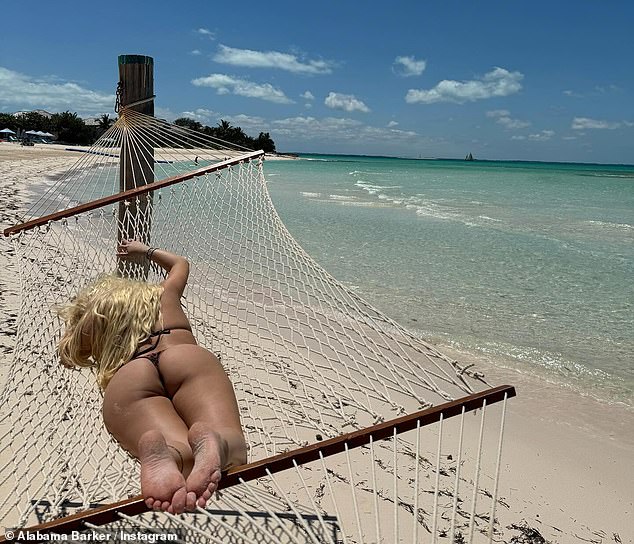 Another picture was taken as Barker soaked up the warm sunshine as she rested on a hammock on the sandy shore