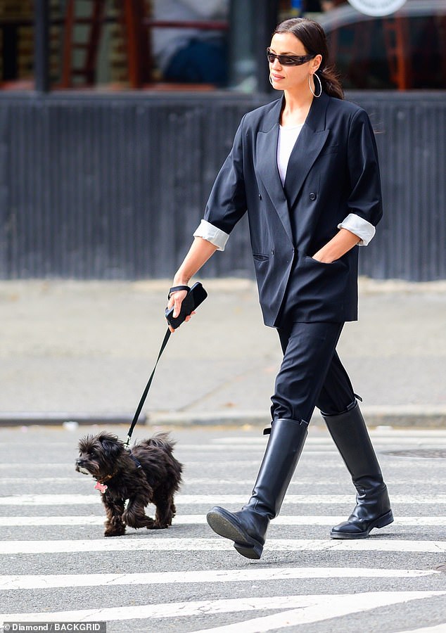 Her dark brown hair was pulled back into a sleek low ponytail and she accessorized with large hoop earrings and black sunglasses