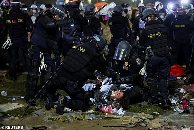 LAPD protester apprehending a protester as the break through the encampment