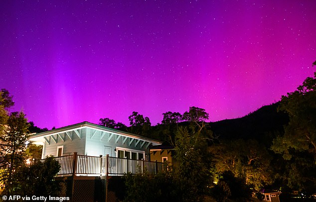 Northern lights or aurora borealis illuminate the night sky over a camper's tent north of San Francisco in Middletown, California on May 11, 2024