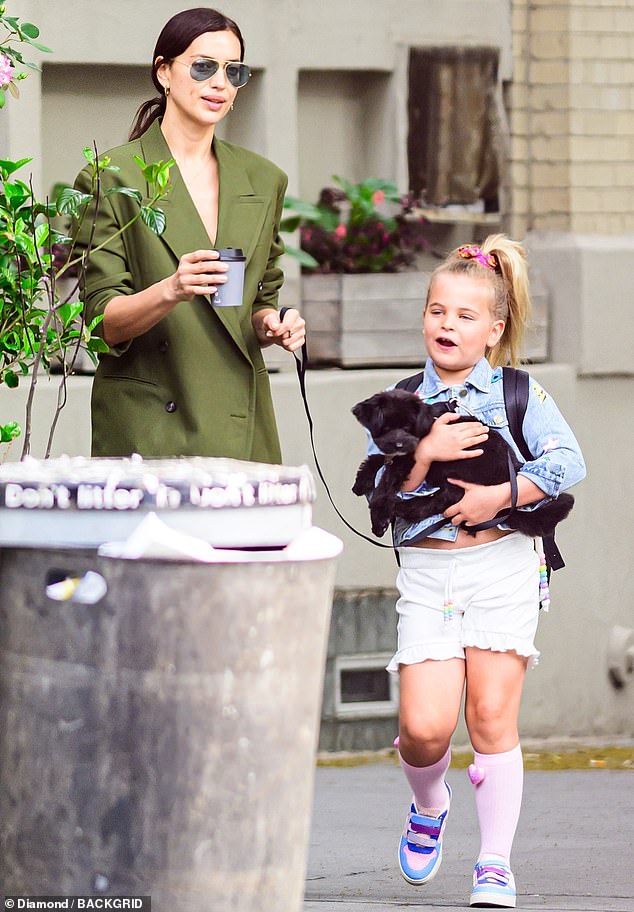 Lea De Seine, six, whose father is Hollywood heartthrob Bradley Cooper , could be seen affectionately cradling her beloved pooch