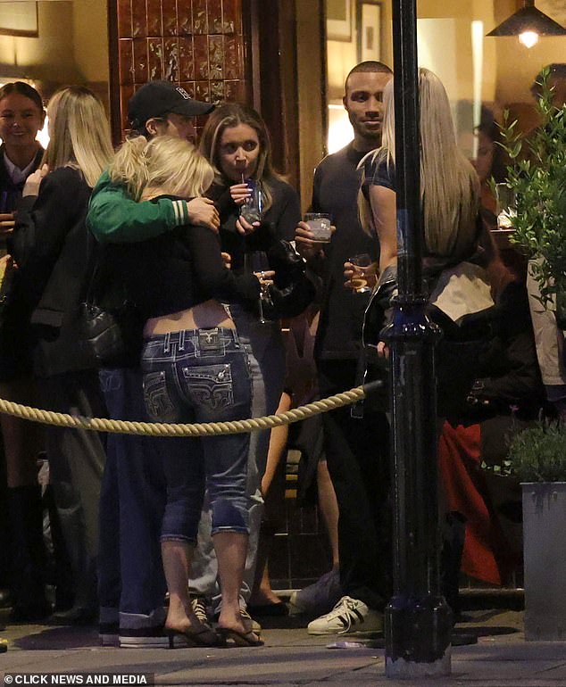 A male pal put his arm around the star as she chatted with her friends outside a bar