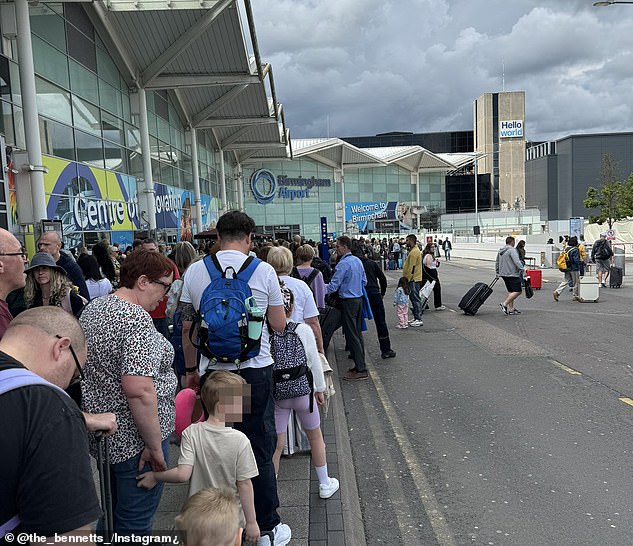Families wait outside the terminal at Birmingham Airport yesterday as they queue to get inside