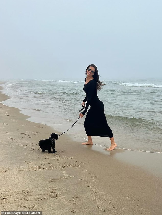 Another photo showed the Vogue cover girl wearing a long black dress as she took her dog for a walk on the beach