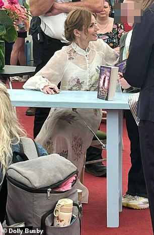 The Spice Girl smiled as she posed with children at the Hay Festival where she is promoting her latest book, Rosie Frost and the Falcon Queen