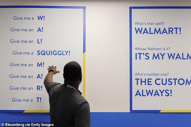 Walmart manager Greg Harden gestures to a sign during a meeting at his Dallas-area store, where he oversees some $100million in sales annually