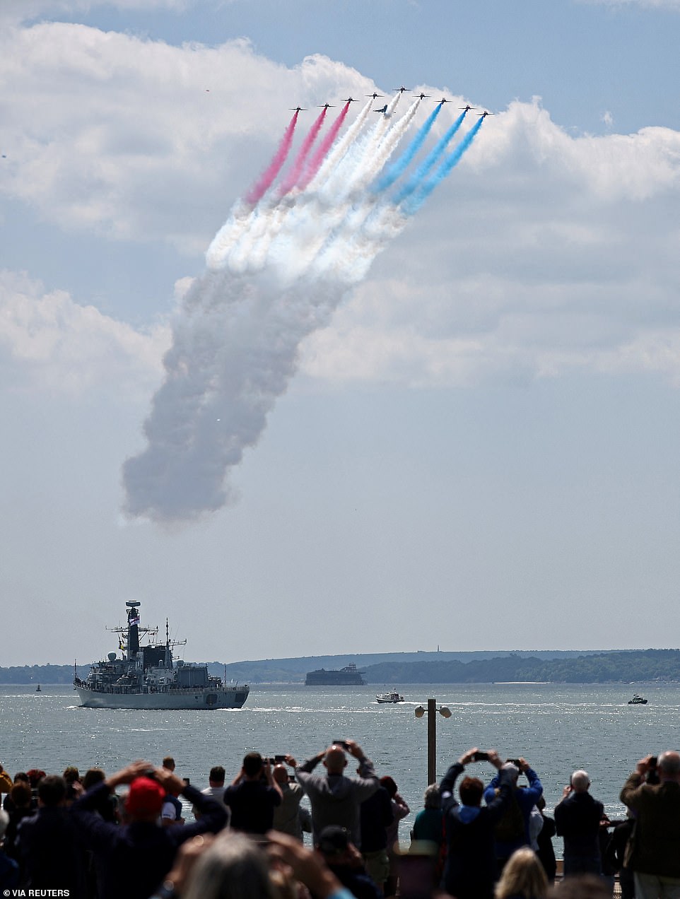 Members of the public pictured watching as the Red Arrows perform a flypast above HMS St Albans, a Type 23 Frigate, this afternoon