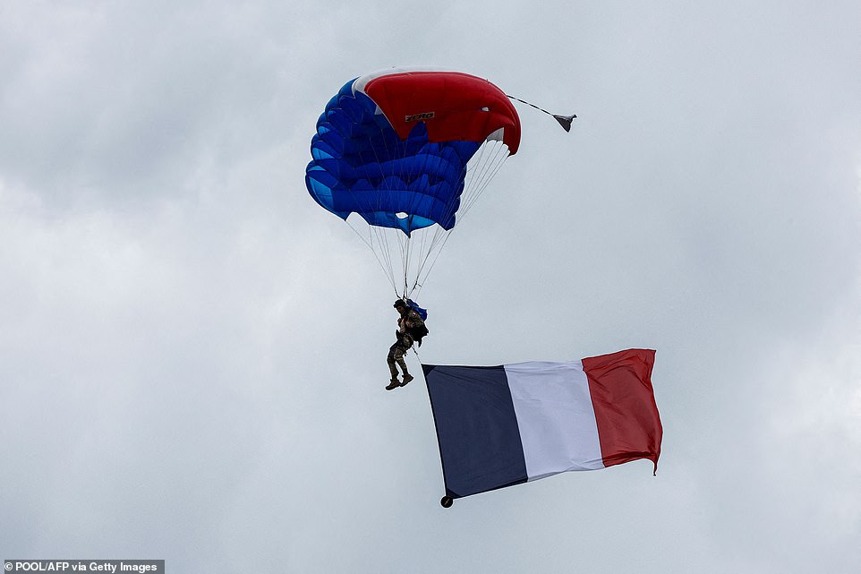 A French 1st RPIMa Special Forces paratrooper flies a French national flag beneath his red, white and blue parachute canopy, during a ceremony commemorating SAS paratroopers and Free French Forces who died in Brittany during World War II, at La Gree mill SAS (Special Air Service) memorial in Plumelec, western France