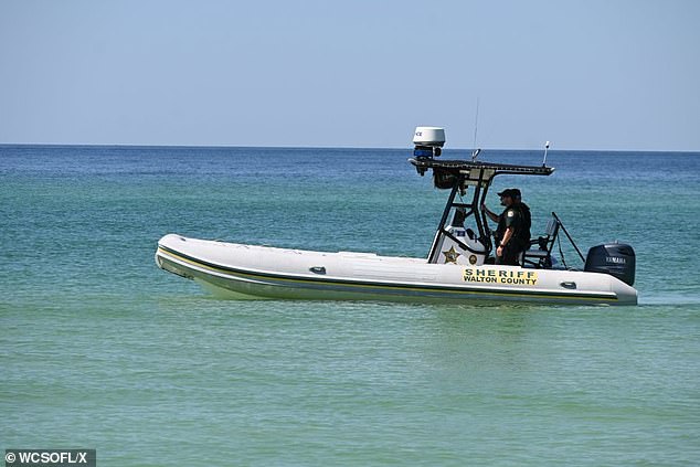 Sheriff's deputies are pictured out monitoring the waters near where the shark attacks took place on Friday