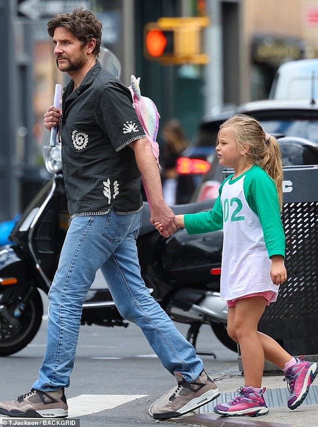 Cooper kept it casual for the daytime excursion wearing a black button up that was partially unfastened around the collar and contained white-embroidered details on the material