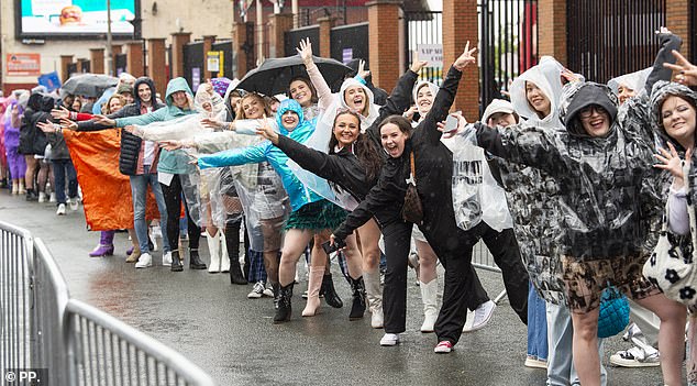 Taylor Swift fans battle the bad weather and wear ponchos outside Anfield