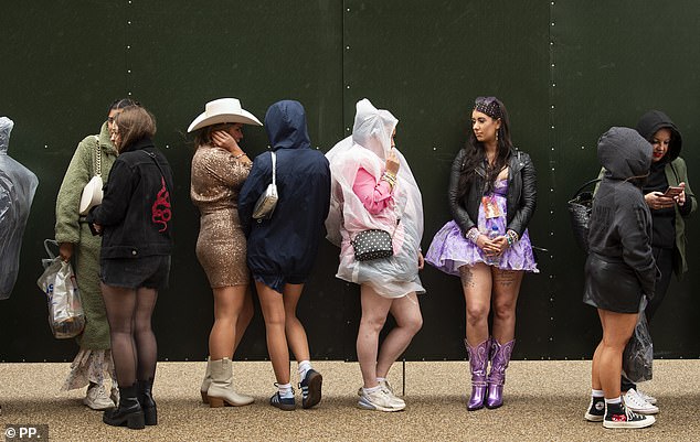 .Taylor Swift fans battle the elements and wear poncho's outside Anfield