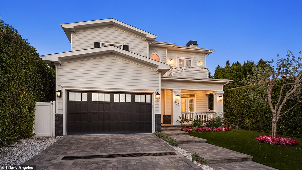 Equipped with a garage and driveway, the 'office house' features a gate at the front of the lawn to provide the owner a level of added security