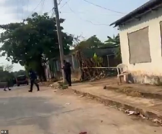 Mexican cops guard the clandestine bar where six people were stabbed dead and nine were wounded. The attack was allegedly carried out by three men who arrived on motorcycles