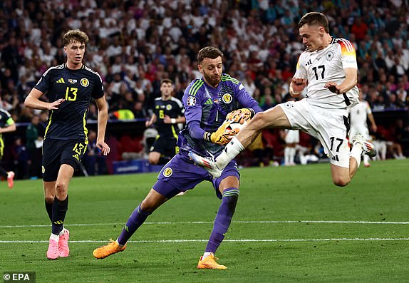 epa11410954 Goalkeeper Angus Gunn of Scotland (C) in action against Florian Wirtz of Germany (R) as Jack Hendry of Scotland Looks on during the UEFA EURO 2024 group A match between Germany and Scotland in Munich, Germany, 14 June 2024.  EPA/ANNA SZILAGYI