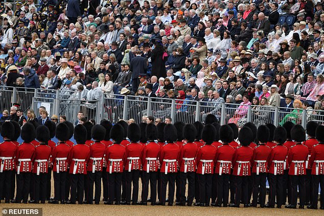 Audience members watch the Trooping the Colour parade in London today