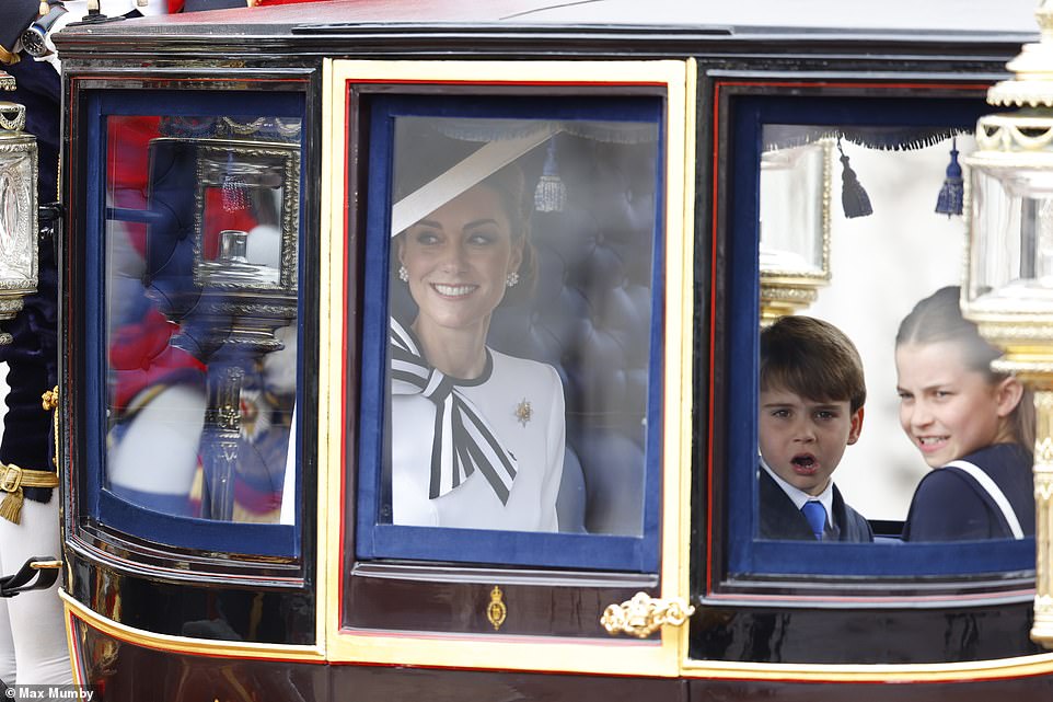 The Princess of Wales smiles from her carriage as she leaves Buckingham Palace with Prince George and Princess Charlotte