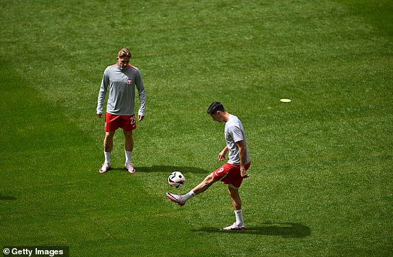 HAMBURG, GERMANY - JUNE 16: Robert Lewandowski of Poland warms up with teammate Michal Skoras prior to the UEFA EURO 2024 group stage match between Poland and Netherlands at Volksparkstadion on June 16, 2024 in Hamburg, Germany.   (Photo by Dan Mullan/Getty Images)