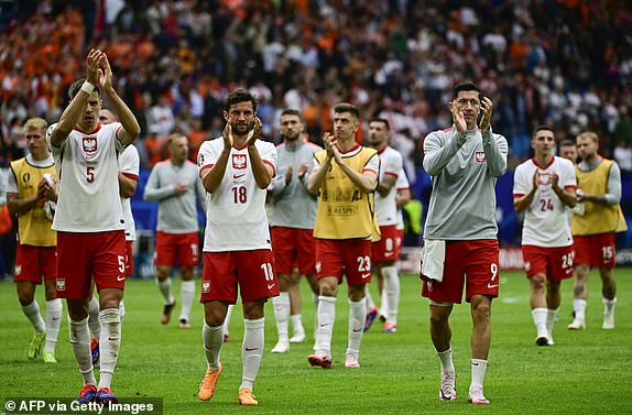 (From L) Poland's defender #05 Jan Bednarek, Poland's defender #18 Bartosz Bereszynski and Poland's forward #09 Robert Lewandowski acknowledge the public at the end of the UEFA Euro 2024 Group D football match between Poland and the Netherlands at the Volksparkstadion in Hamburg on June 16, 2024. (Photo by JOHN MACDOUGALL / AFP) (Photo by JOHN MACDOUGALL/AFP via Getty Images)