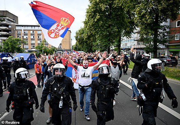 Soccer Football - Euro 2024 - Fans gather before Serbia v England - Gelsenkirchen, Germany - June 16, 2024 Police officers watch Serbia fans in the street ahead of the match REUTERS/Jana Rodenbusch