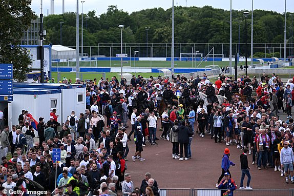 GELSENKIRCHEN, GERMANY - JUNE 16: A general view as fans of England queue to go through a security checkpoint as they are search before entering the stadium prior to the UEFA EURO 2024 group stage match between Serbia and England at Arena AufSchalke on June 16, 2024 in Gelsenkirchen, Germany.   (Photo by Matthias Hangst/Getty Images)