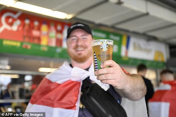 A supporter of England holds a reduced-strength beer prior to the UEFA Euro 2024 Group C football match between Serbia and England at the Arena AufSchalke in Gelsenkirchen on June 16, 2024. Gelsenkirchen has been declared high risk by the police due to fears Serbian ultras could clash with the tens of thousands of England fans that have made the trip to north-west Germany. (Photo by INA FASSBENDER / AFP) (Photo by INA FASSBENDER/AFP via Getty Images)