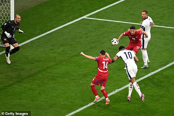 GELSENKIRCHEN, GERMANY - JUNE 16: Jude Bellingham of England scores his team's first goal from a header whilst under pressure from Andrija Zivkovic of Serbia during the UEFA EURO 2024 group stage match between Serbia and England at Arena AufSchalke on June 16, 2024 in Gelsenkirchen, Germany.   (Photo by Matthias Hangst/Getty Images)