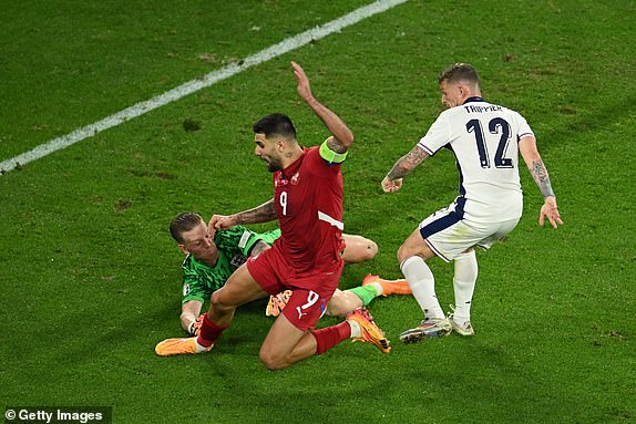 GELSENKIRCHEN, GERMANY - JUNE 16: Aleksandar Mitrovic of Serbia is challenged by Kieran Trippier of England as Jordan Pickford attempts to make a save during the UEFA EURO 2024 group stage match between Serbia and England at Arena AufSchalke on June 16, 2024 in Gelsenkirchen, Germany.   (Photo by Matthias Hangst/Getty Images)