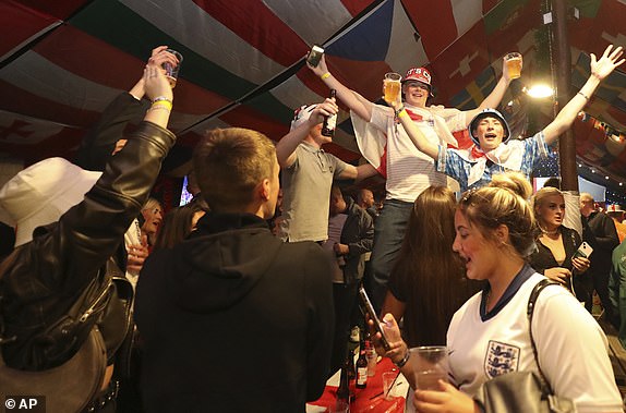 England fans celebrate after the end of the Group C match between Serbia and England in the Euro 2024 soccer tournament after watching on large TV screens at the Douglas Tavern in Hebburn, England, Sunday, June 16, 2024. England won the match 1-0. (AP Photo/Scott Heppell)