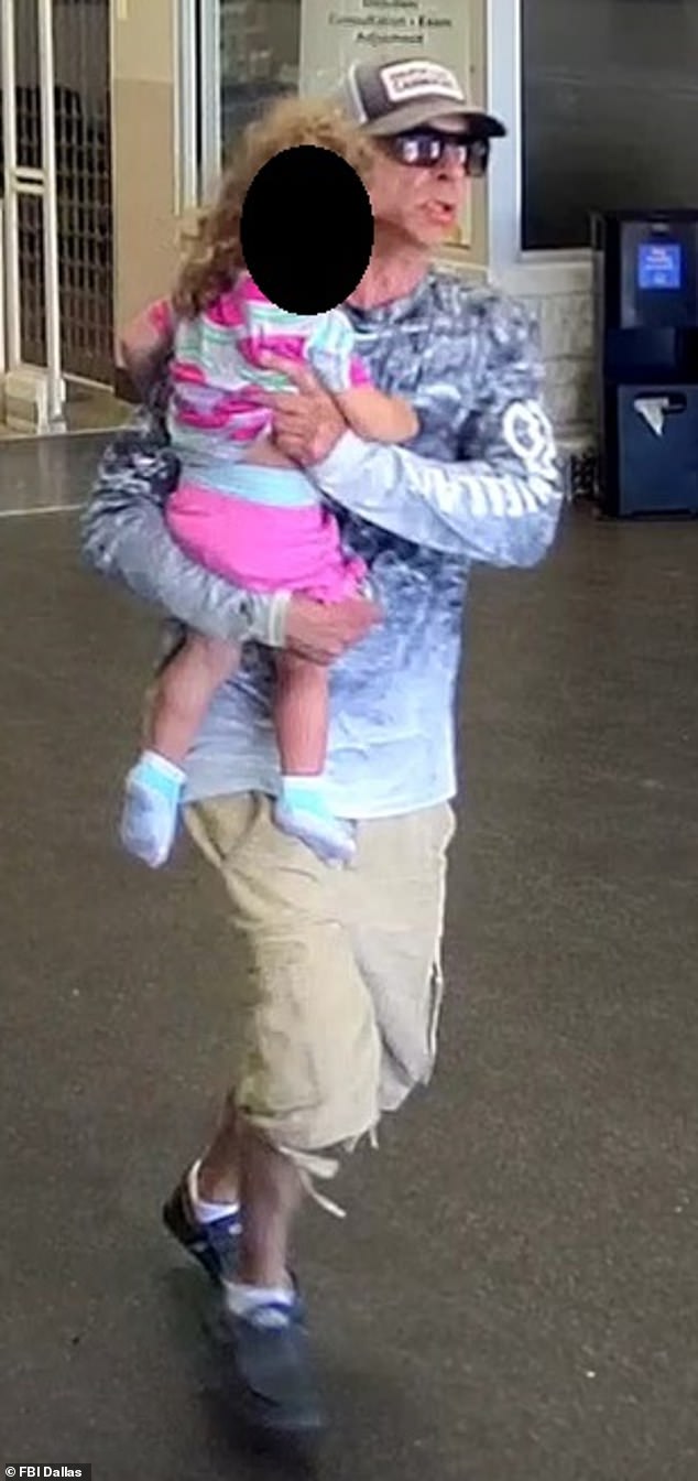 The suspect makes his escape from the Walmart at Anderson Boulevard in Fort Worth with the child in his arms after his raid on the First Convenience branch inside