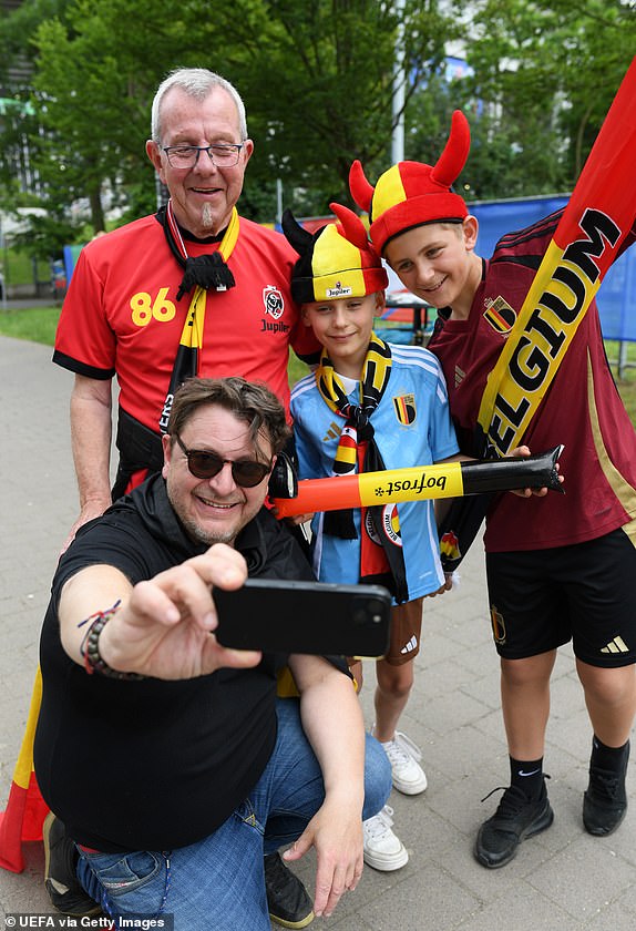 FRANKFURT AM MAIN, GERMANY - JUNE 17: Fans of Belgium take a selfie on the outside of the stadium prior to the UEFA EURO 2024 group stage match between Belgium and Slovakia at Frankfurt Arena on June 17, 2024 in Frankfurt am Main, Germany. (Photo by Charles McQuillan - UEFA/UEFA via Getty Images)