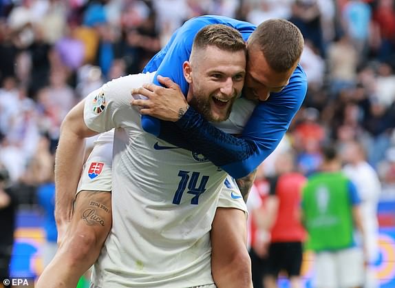 epa11418548 Milan Skriniar of Slovakia celebrates with a teammate after winning the UEFA EURO 2024 group E match between Belgium and Slovakia, in Frankfurt Main, Germany, 17 June 2024.  EPA/CLEMENS BILAN