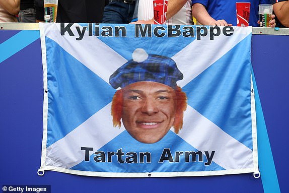 DUSSELDORF, GERMANY - JUNE 17:  Kylian Mbappe of France is shown on a Scotland flag prior to the UEFA EURO 2024 group stage match between Austria and France at Dusseldorf Arena on June 17, 2024 in Dusseldorf, Germany.(Photo by Chris Brunskill/Fantasista/Getty Images)