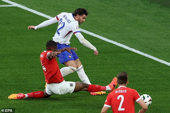 epa11418714 Theo Hernandez of France (top) in action against Kevin Danso of Austria during the UEFA EURO 2024 group D soccer match between Austria and France, in Dusseldorf, Germany, 17 June 2024.  EPA/GEORGI LICOVSKI