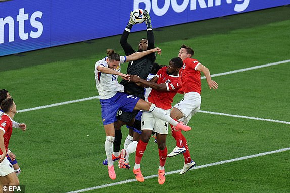 epa11418732 Goalkeeper Mike Maignan of France (C) in action during the UEFA EURO 2024 group D soccer match between Austria and France, in Dusseldorf, Germany, 17 June 2024.  EPA/GEORGI LICOVSKI