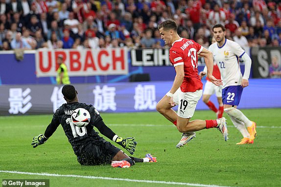 DUSSELDORF, GERMANY - JUNE 17: Mike Maignan of France saves a shot from Christoph Baumgartner of Austria during the UEFA EURO 2024 group stage match between Austria and France at DÃ¼sseldorf Arena on June 17, 2024 in Dusseldorf, Germany. (Photo by Dean Mouhtaropoulos/Getty Images)