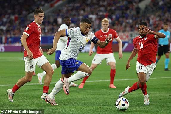 France's forward #10 Kylian Mbappe is dribbling Austria's defender #16 Philipp Mwene during the UEFA Euro 2024 Group D football match between Austria and France at the Duesseldorf Arena in Duesseldorf on June 17, 2024. (Photo by FRANCK FIFE / AFP) (Photo by FRANCK FIFE/AFP via Getty Images)