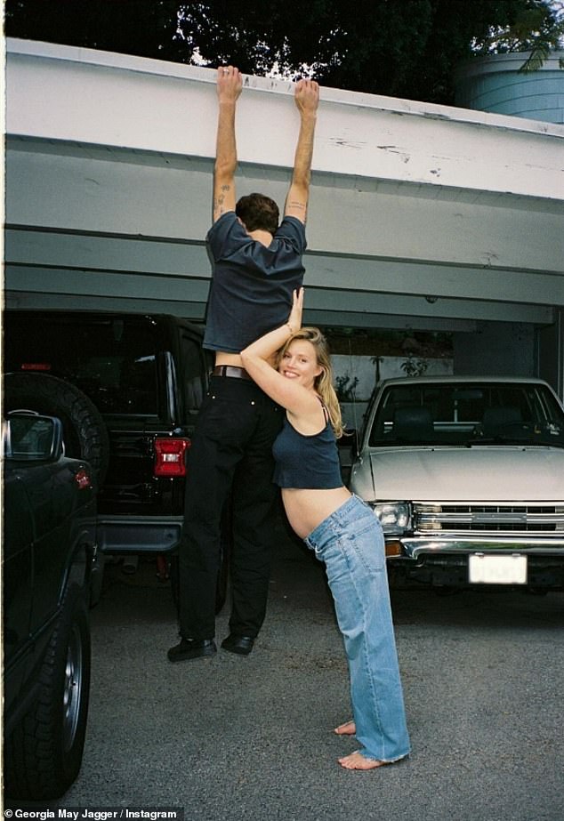 Wearing jeans, a second image showed her playfully leaning against Cambryan who was swinging from his garage door as she smiled while barefoot