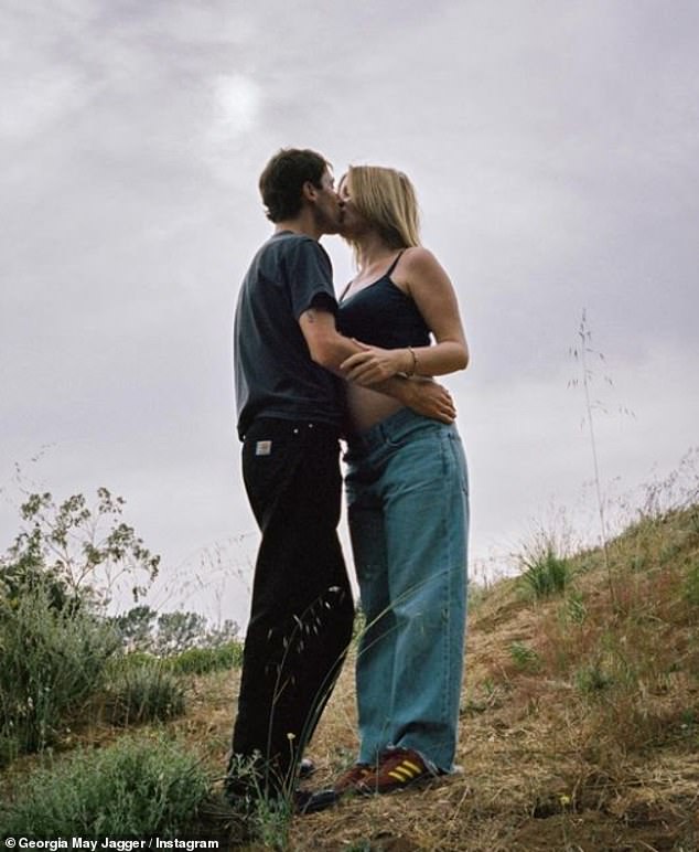 In another snap, the expectant parents shared a passionate kiss in a field, while Cambryan embraced her bump