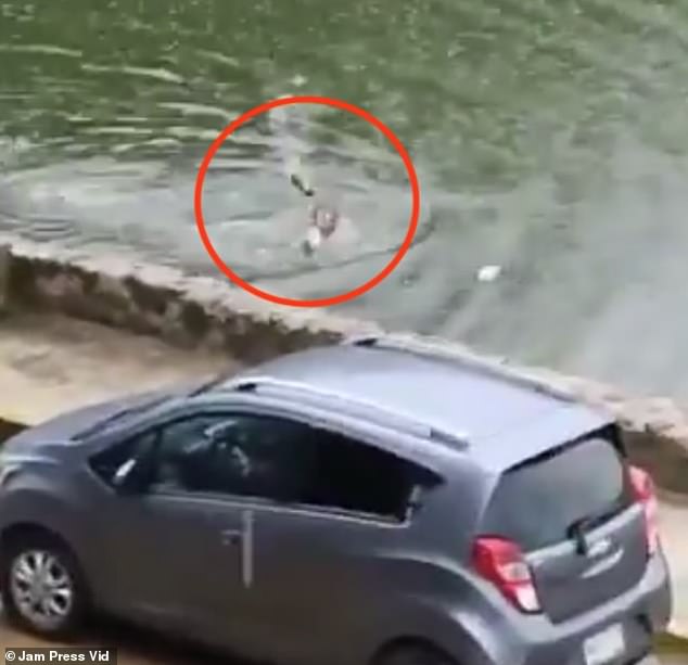 Before he climbed out of the murky water, the man threw off his shoes onto land